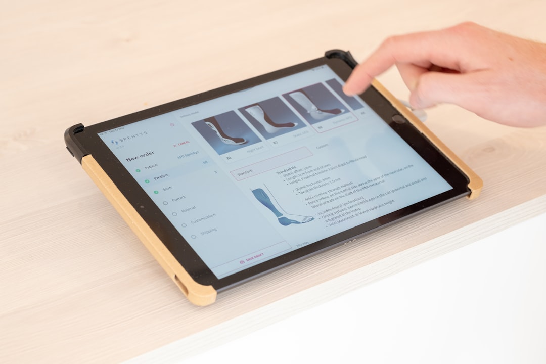 A professional uses state-of-the-art orthotic design software on a tablet, demonstrating the seamless blend of technology and healthcare to customize patient treatment.
